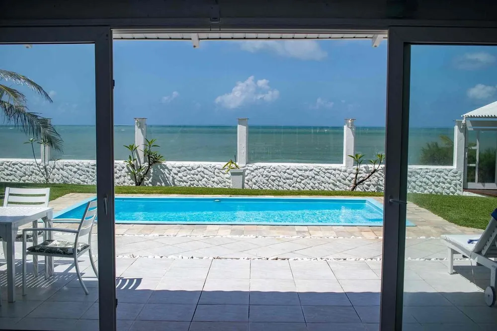 Sliding doors opening onto the pool with the ocean behind
